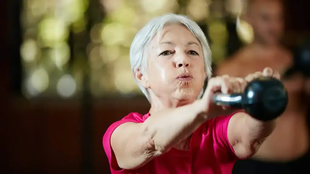 Toning Arms After 60: Empowering Womens Fitness Through Effective Weight Training 1 Older woman doing weight training Deal to help her strength and longevity