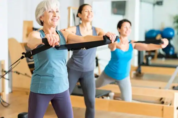 Toning Arms After 60: Empowering Womens Fitness Through Effective Weight Training 2 older woman doing weight training Deal and resistance in the gym to tone upper arms