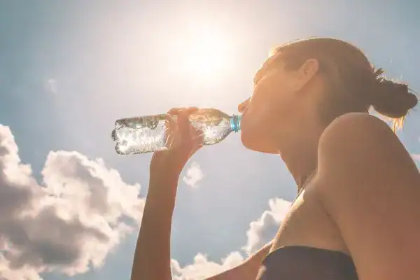 Hydration: The Secret Ingredient for a Toned Stomach and Enhanced Fitness 3 Image of woman drinking water to hydrate Deal after run.